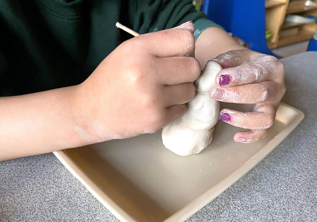 student carving air-dry clay
