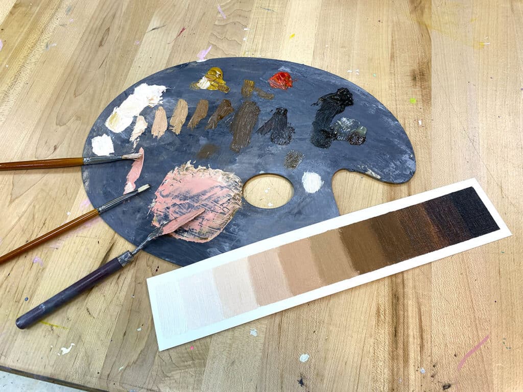paint palette with a skin tone scale and brushes