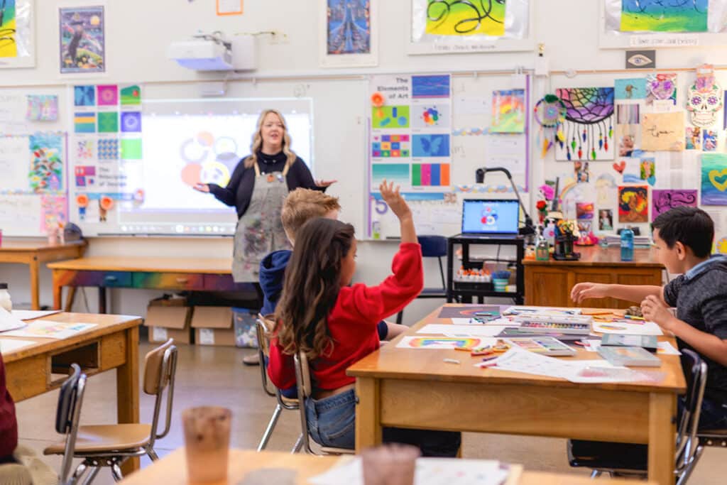 teacher instructing at a whiteboard with students