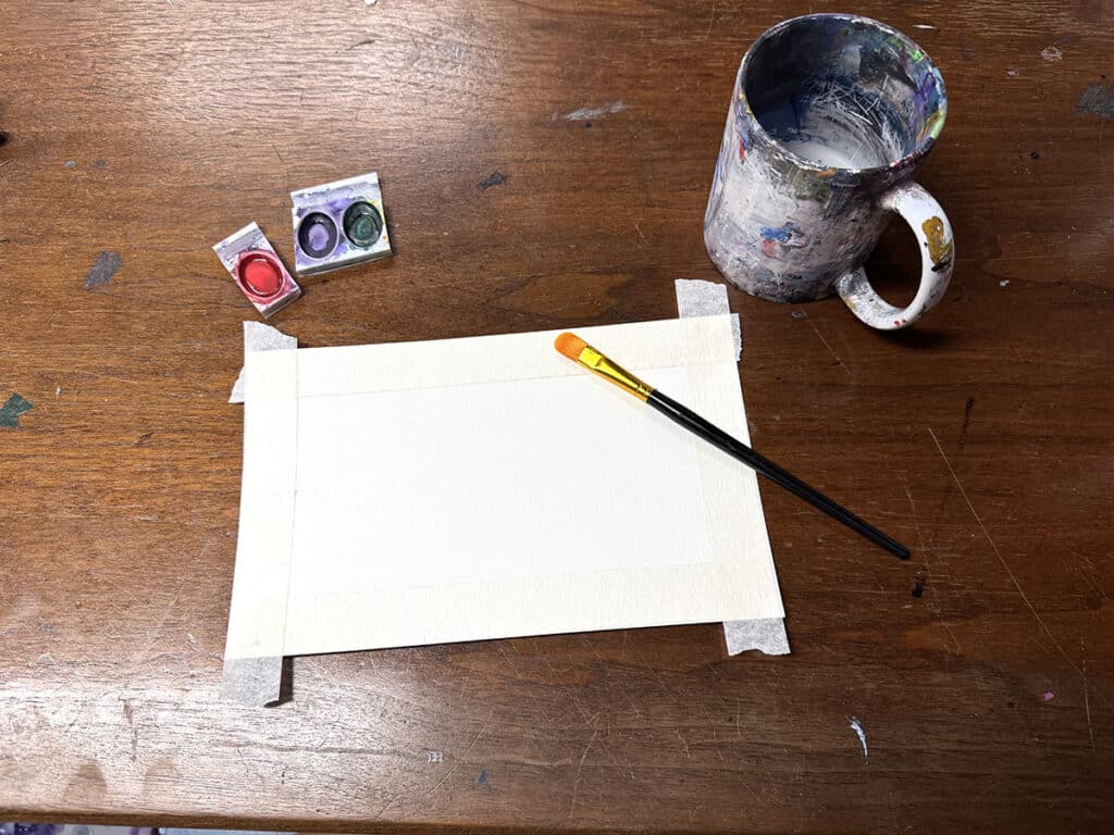 blank paper, mug, brush, and watercolor paints