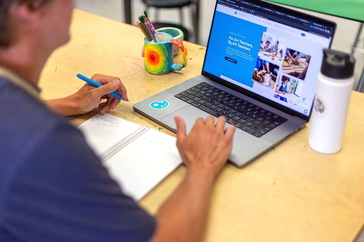 teacher on a laptop looking at the master's degree landing page