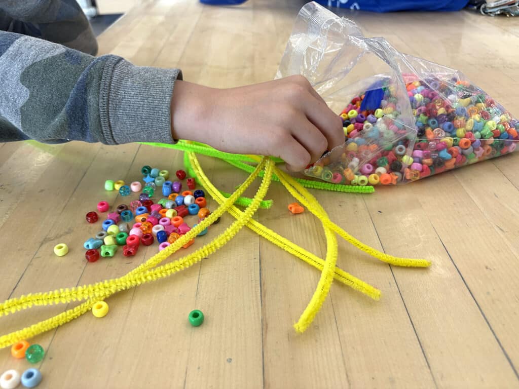 student grabbing beads