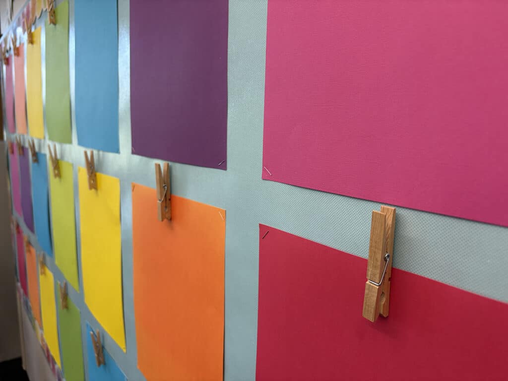 colored paper with clothespins on a board