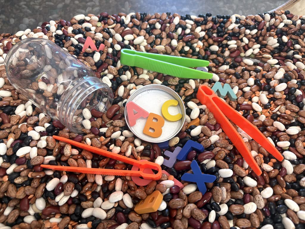 bean sensory bin with tweezers
