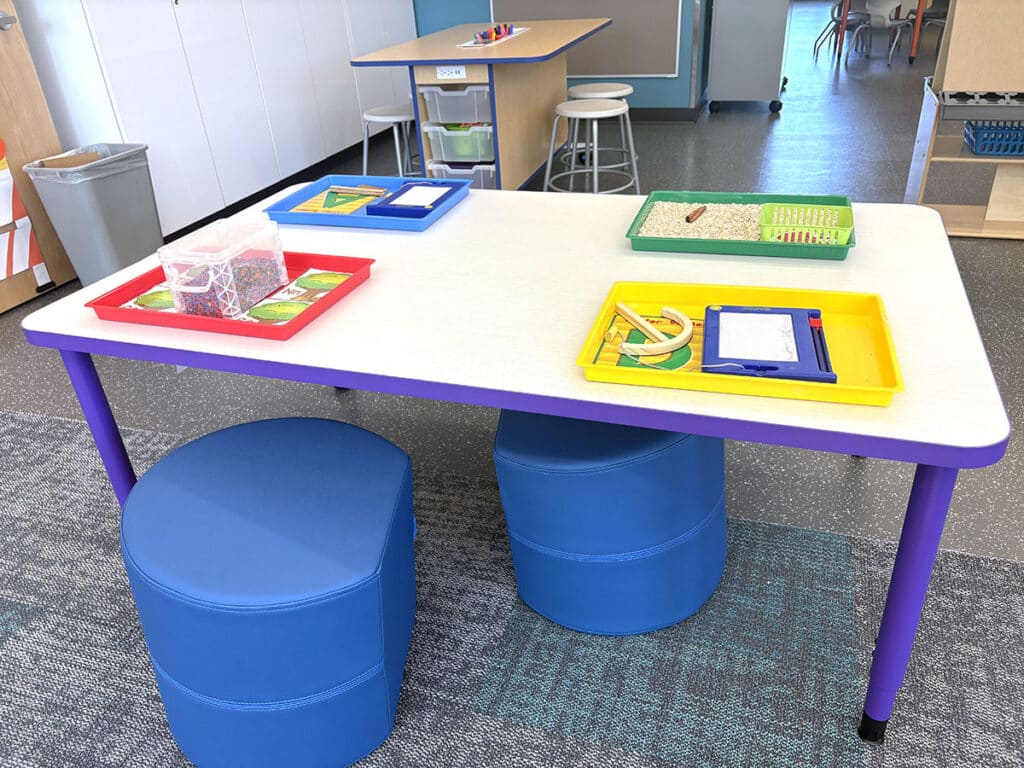 table with stools and trays of activities