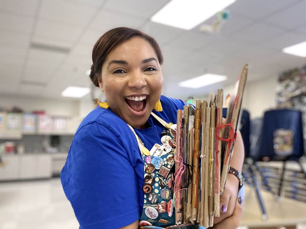 jenn russell with a stack of sketchbooks