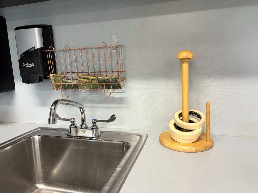 sink area with sponge basket and paper towel tape holder